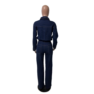 Rear view of slim fit dark blue denim jumpsuit with waist seam and back pockets