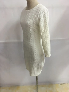 Détail de la maille torsadée sur la robe beige ajustée à manches longues