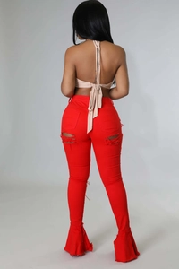 Detailansicht roter Schlagjeans mit Distressed-Cuts am Oberschenkel und ausgefranstem Saum