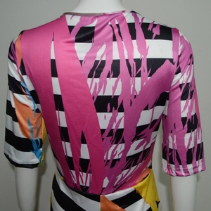 Dettaglio di pennellate rosa su tessuto elastico a righe bianche e nere della maglia