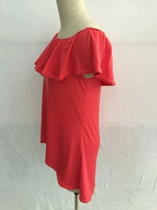 Détail de la robe rouge à épaules dénudées avec décolleté à volants et maille ajustée