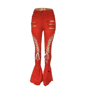 Detail der roten Schlagjeans mit Distressed-Löchern und seitlicher Schnürung mit Ösen