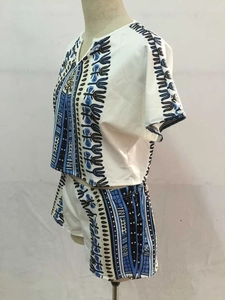 Side view of a white two-piece summer set with blue ethnic prints on a display mannequin