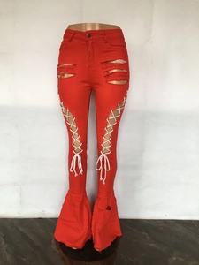 Detail der roten Schlaghose mit Schnürung und modischen Rissen für einen trendigen Look