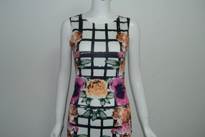 Detalle de un vestido blanco con estampado de rosas naranjas y diseño de cuadrícula