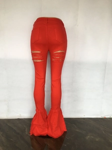 Detailansicht der roten Schlagjeans mit Distressed-Löchern und ausgefranstem Glockensaum