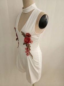 Detailed embroidery of red and green flowers on a white halter neck romper for women