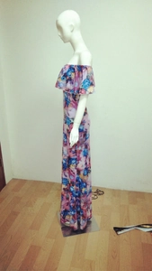 Detail of floral off-shoulder maxi dress with ruffled neckline and colorful abstract print