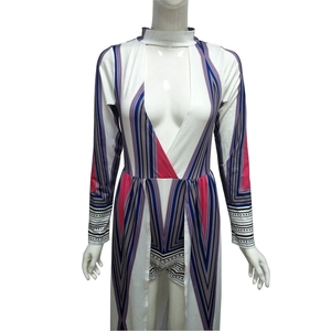 Detail view of geometric print jumpsuit dress with long sleeves and deep V-neck cutout