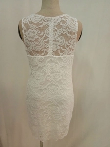 Dettaglio del retro dell'abito in pizzo bianco con ricami floreali e cerniera nascosta