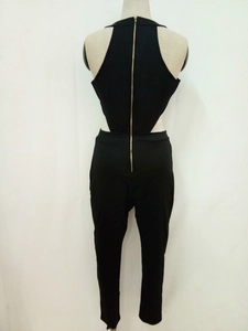 Detail des Jumpsuits mit Rückenausschnitt und goldenem Reißverschluss auf schwarzem Stoff