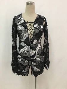 Detail of black crochet lace romper featuring white lining and adjustable front tie-up cord