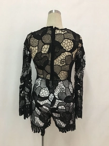 Detail of black floral lace romper featuring intricate mesh patchwork and back zipper
