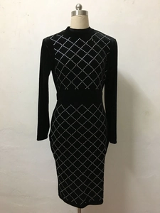Detailed view of silver rhinestone diamond patterns on black velvet dress fabric