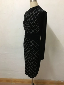 Detailed view of silver rhinestone grid patterns on a black long-sleeved dress