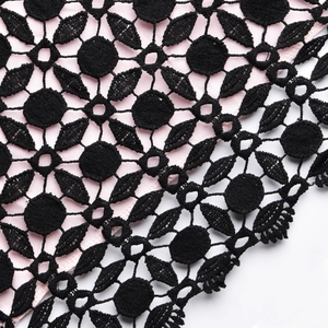 Gros plan sur la dentelle florale noire avec doublure rose pour robe ajustée chic