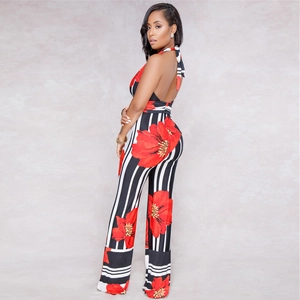 Detail of backless halter jumpsuit with bold vertical stripes and red floral print