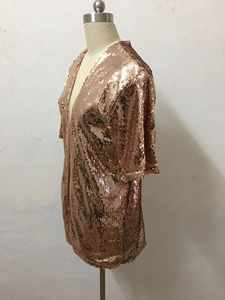 Detail eines Pailletten-Cardigans in Roségold für Partys mit glänzender Textur