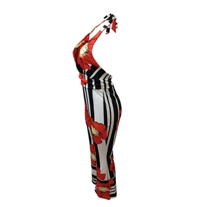 Detail view of striped jumpsuit showing black and white vertical lines with red floral print
