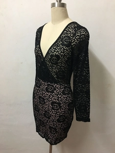 Détail d'une robe en dentelle noire avec décolleté en V profond et broderie florale
