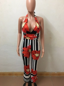 Macro detail of high-waist halter jumpsuit featuring red floral prints and vertical stripes
