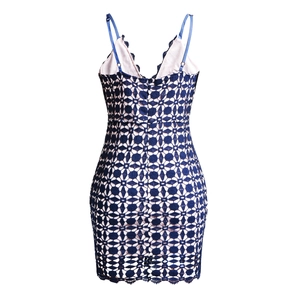 Détail d'une robe en dentelle bleu foncé avec motifs floraux ajourés et fines bretelles