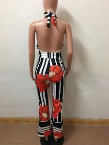 Detail of sexy backless jumpsuit with vertical black stripes and large red floral print