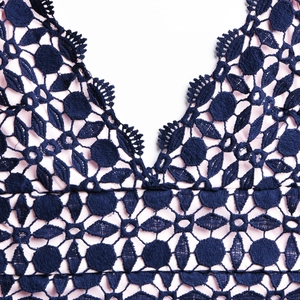 Détail du décolleté en V en dentelle marine avec doublure rose et broderie