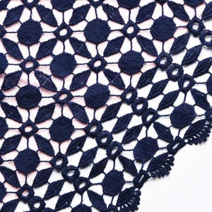 Détail de la dentelle crochet bleu marine avec doublure rose sur une robe ajustée