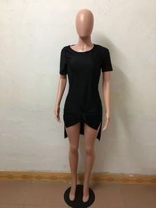 Detail of black short sleeve dress featuring front twist knot and asymmetrical hem