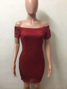 Dettaglio della trama in pizzo floreale rosso scuro e dello scollo a barchetta del vestito