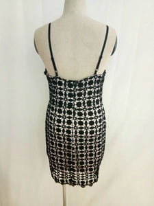 Détail de la dentelle crochetée noire avec doublure rose sur une robe ajustée