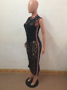 Dettaglio del tessuto in pizzo floreale nero con bordino a righe rosse e bianche e cerniera