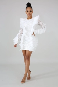 Dettaglio del pizzo floreale bianco con volant su un mini abito elegante da donna