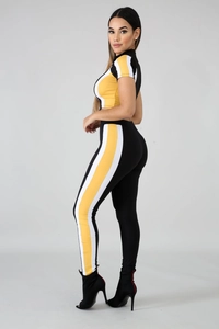 Detail of a color-block sporty two-piece set featuring black, yellow, and white panels