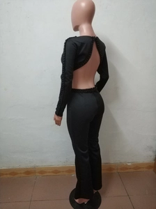 Detail eines schwarzen rückenfreien Overalls mit Perlenärmeln und weiter Hose