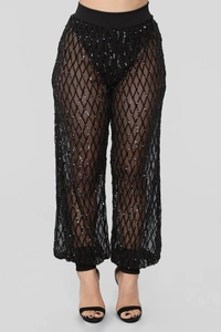 Détail du pantalon noir à paillettes taille haute avec motifs de losanges brillants
