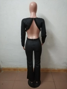 Detail der Perlenverzierung am rückenfreien Langarm-Jumpsuit mit Schlaghose in Schwarz