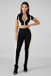 Front view of two-piece patchwork tracksuit featuring high neck zipper top and slim trousers