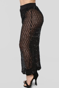 Détail du pantalon en résille noire avec paillettes argentées et taille élastique chic
