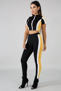 Detail view of a two-piece women's sports set with tricolor vertical patchwork panels