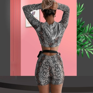 Rear view of women's two-piece snakeskin print set with hooded crop top and high waist shorts