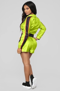 Detail van neongroene sportset met zijstrepen op de mouwen van de jas en de short