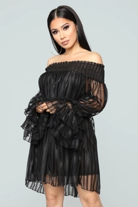 Détail d'une robe mini à épaules dénudées avec volants et tissu en maille texturée