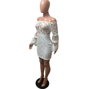 Detail shot of intricate floral lace patterns and scalloped hem on the white mini dress