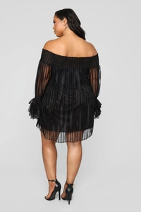 Détail d'une robe mini à épaules dénudées avec voile ondulé et manches à volants