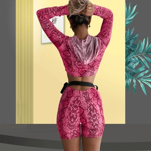 Detail view of the back showing a slim fit pink snakeskin print hooded crop top and shorts