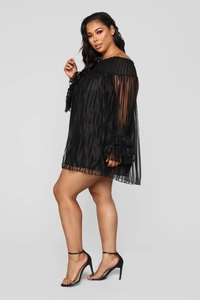 Détail de la robe mini noire en tulle avec texture ondulée et volants aux épaules nues