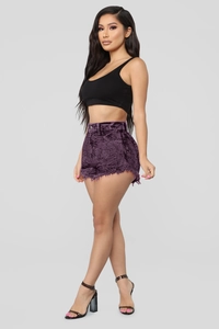 Détail du short violet taille haute avec ourlets effilochés et texture en velours