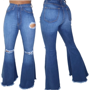Women's high waist flared jeans with distressed ripped details and raw hem in blue wash